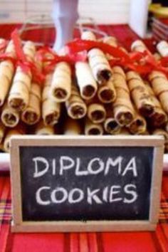 there is a sign that says diploma cookies on the table next to some cinnamon rolls