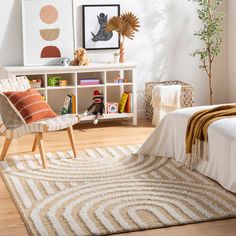 a bedroom with a bed, chair and bookshelf filled with toys in it