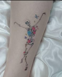 a woman's leg with a skeleton and flowers on it