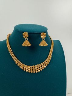 This exquisite piece of craftsmanship comes from our Traditional collection. Finish: 24 grams gold finish Necklace Fastening: Adjustable Dori Earring Fastening: Push Back Contains: 1 necklace, 1 pair of earrings Antique Gold Necklace, Gold Necklace Indian, Temple Jewelry, Necklace Indian, South Indian Jewelry, Indian Wedding Jewelry, Temple Jewellery, Jewelry Wedding, Wedding Necklace