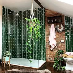 a bathroom with green tile and wooden floors