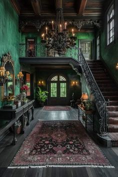 an ornate staircase leads up to the second floor in this green room with chandelier