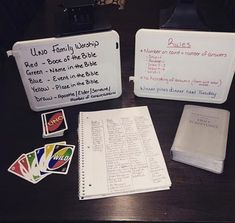 a table topped with lots of writing and papers next to a binder filled with notes