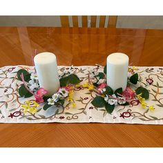 two white candles sitting on top of a table