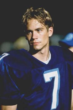 a young man in a football uniform looking at the camera