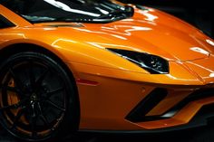 an orange sports car parked in a garage