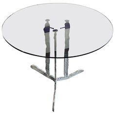 a glass table with two people standing on it's legs and one person sitting at the top