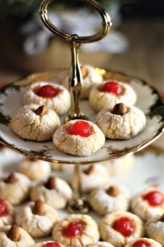 small pastries are displayed on a plate with a gold stand and pine tree in the background