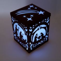 a black and white light up cube with nativity scene on the side, in front of a gray background