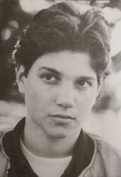 an old photo of a young man in black and white, looking at the camera