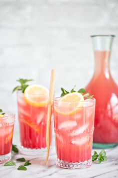 two glasses filled with watermelon lemonade and garnished with mint leaves