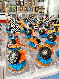 cupcakes with cars and flags are on display at a race car themed birthday party