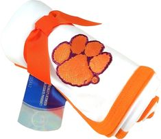 an orange and white towel with a paw print on it, sitting next to a roll of toilet paper