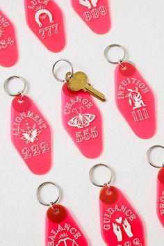 six pink key tags with different designs on them