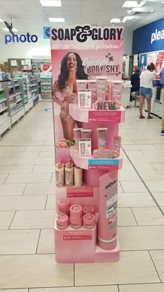 a display in a store filled with lots of pink products and people walking past it