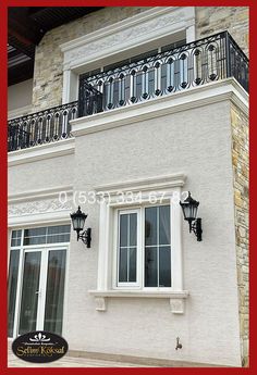 an image of a house that is white and has black balconies on the balcony