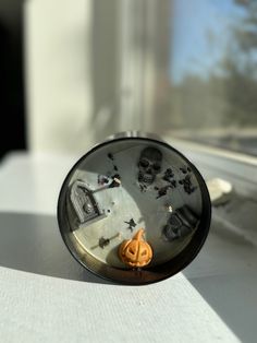 an alarm clock with halloween decorations on it sitting in front of a window sill