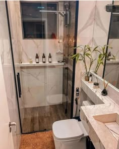 a bathroom with a toilet, sink and shower stall is pictured in this image from the front view