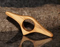 a wooden object sitting on top of a table next to a piece of driftwood