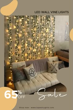 a living room with lights on the wall and a white couch in front of it