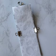 a towel with two rings on it sitting on top of a marble counter next to a pair of scissors