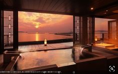 an outdoor jacuzzi with candles lite up at sunset or dawn, overlooking the water