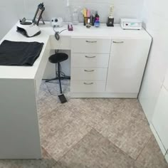 a white desk topped with lots of clutter next to a wall mounted microwave oven