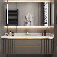 a modern bathroom with marble counter tops and gold accents on the sink area, along with an illuminated towel rack