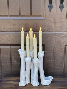 a group of white candles sitting in front of a door