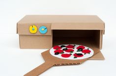 an open cardboard box with a pizza in it and a spatula on the side