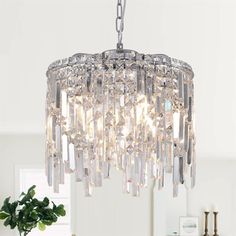 a crystal chandelier hanging from the ceiling in a living room with white walls