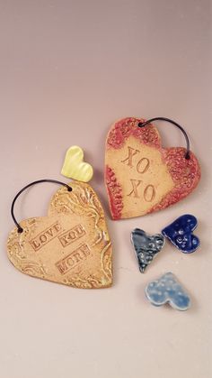 three heart shaped ceramic ornaments on a white surface