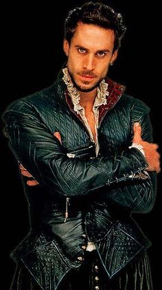 a man with his arms crossed wearing a leather jacket