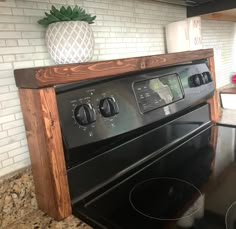 a black stove top oven sitting inside of a kitchen next to a white brick wall