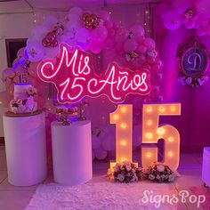 a pink and white room with balloons, lights and decorations on the floor in front of it