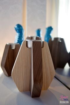 three wooden vases sitting on top of a white table next to blue stringing