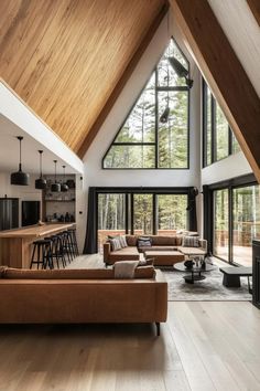 a living room filled with lots of furniture under a vaulted skylight next to a kitchen