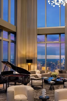 a living room filled with furniture and a grand piano in front of large windows overlooking the city