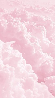 the sky is filled with fluffy clouds in pink and white colors, as seen from an airplane