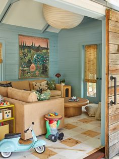 a living room filled with lots of furniture next to a wooden wall and ceiling fan