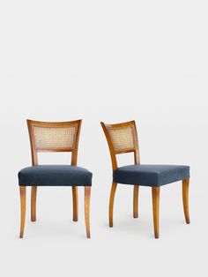 two wooden chairs with blue upholstered seats and backrests, side by side