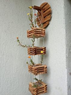 wooden pallet planter hanging on the wall with flowers in them and attached to chains