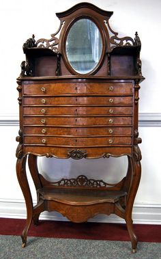 an old wooden dresser with a mirror on it's top and drawers below the drawer