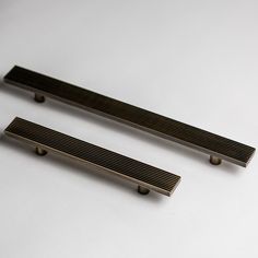 two metal drawer pulls sitting on top of a white table