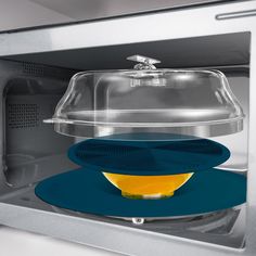 a microwave with a plastic cover on the door and yellow object in front of it