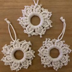 three crocheted ornaments on a wooden table