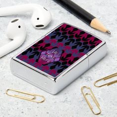 an electronic device sitting on top of a table next to ear buds and paper clips