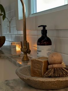 a bathroom sink with soap, shaving brush and lotion bottle on the counter