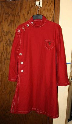 a red shirt hanging on a wooden door with a coat hanger in front of it