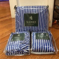 three pieces of blue and white striped bedding sitting on top of a wooden floor